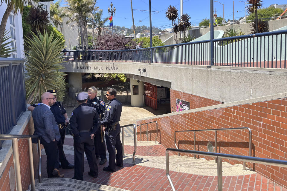 ADDS RAFAEL MANDELMAN Police personnel confer with San Francisco Supervisor Rafael Mandelman, at left, outside the entrance to the Castro Muni Metro station following a shooting in San Francisco, Wednesday, June 22, 2022. One person was killed and another was wounded in a shooting on a crowded subway train early Wednesday, Supervisor Myrna Melgar said. (AP Photo/Janie Har)