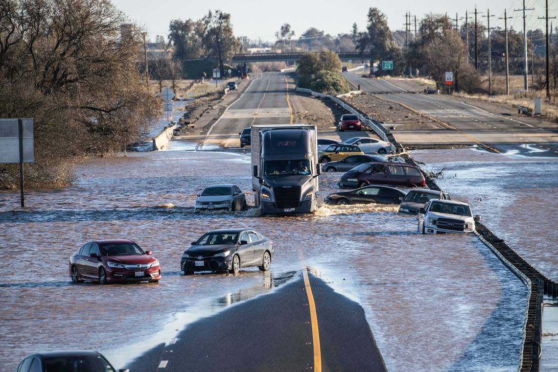 A semi truck drives on Highway 99 past abandoned cars that were stranded in January amid flooding near the Dillard Road exit in south Sacramento County.