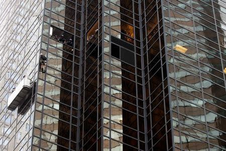 Officers from the NYPD attempt to detain a man as he climbs the outside of Trump Tower in New York, U.S., August 10, 2016. REUTERS/Lucas Jackson