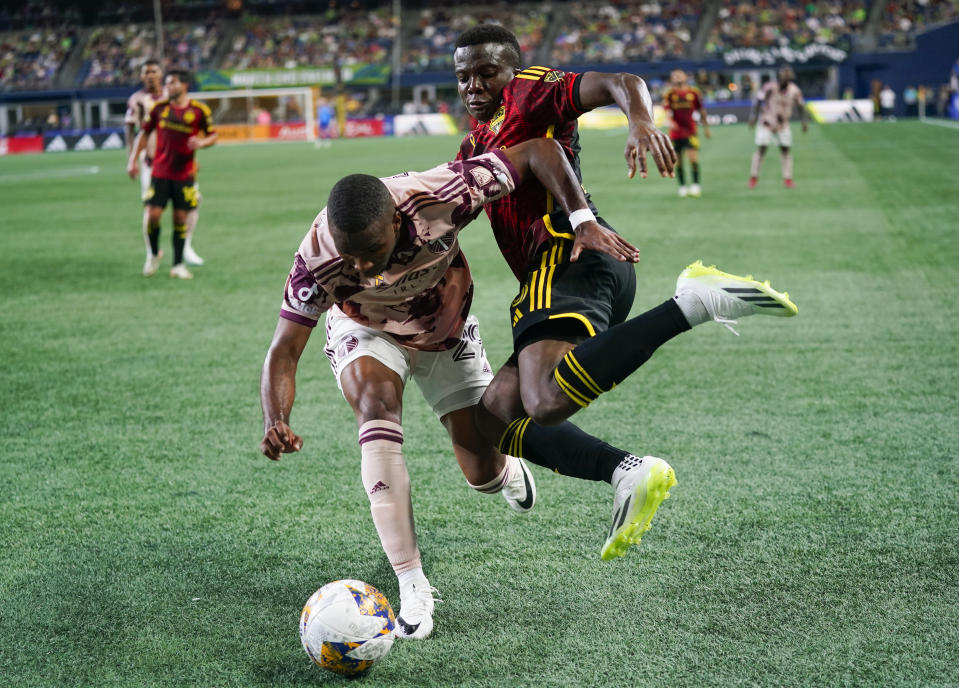 Seattle Sounders defender Nouhou Tolo, right, jumps and twists his body to chip the ball away from Portland Timbers defender Juan David Mosquera during the second half of an MLS soccer match Saturday, Sept. 2, 2023, in Seattle. The teams played to a 2-2 draw. (AP Photo/Lindsey Wasson)