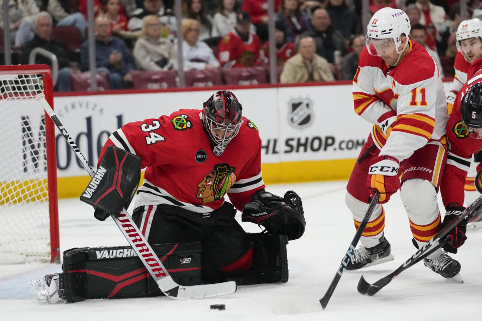 Chicago Blackhawks goaltender Petr Mrazek (34) makes a save against Calgary Flames center Mikael Backlund (11) during the second period of an NHL hockey game Sunday, Jan. 7, 2024, in Chicago. (AP Photo/Erin Hooley)