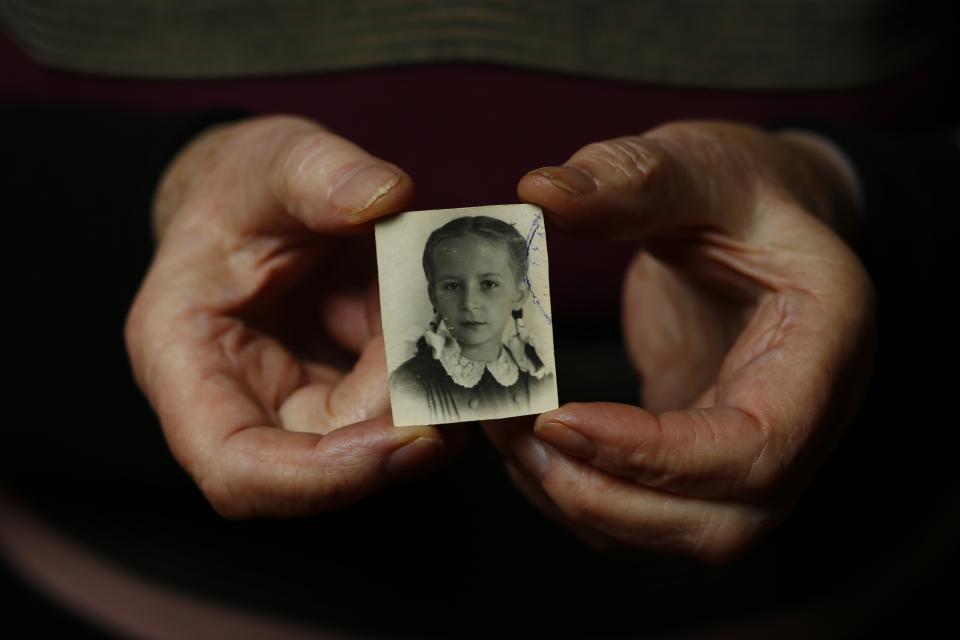 Auschwitz death camp survivor Barbara Doniecka holds up wartime a photo of herself in Warsaw