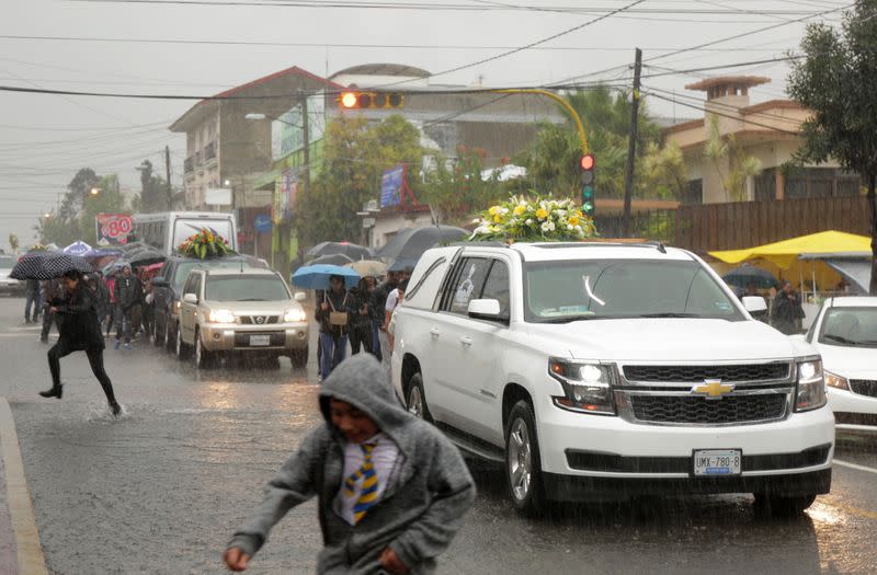 People attend the funeral of several of the victims killed by shooters at a slot-machine arcade in the central Mexican state of Michoacan, in Uruapan