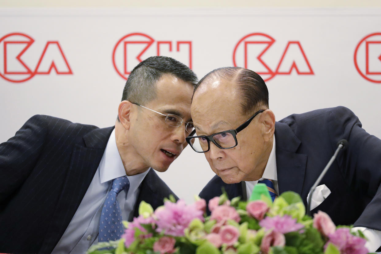Victor Li (right), speaks with his father Li Ka-shing during a news conference in 2018. (Photo: AP Photo/Kin Cheung)
