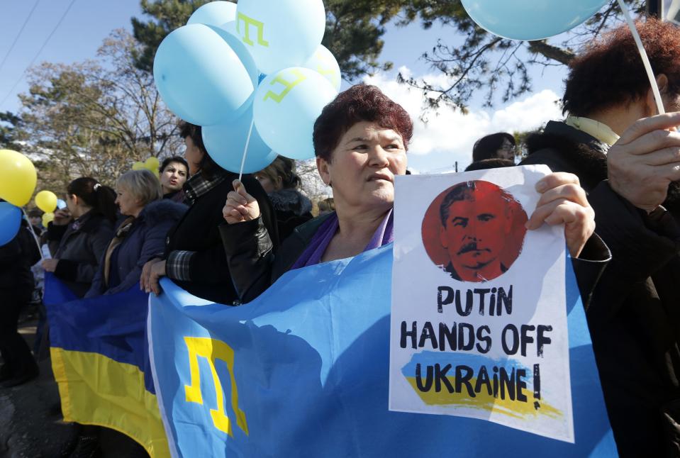 Participants hold placards and shout slogans during an anti-war rally in the Crimean town of Bakhchisaray