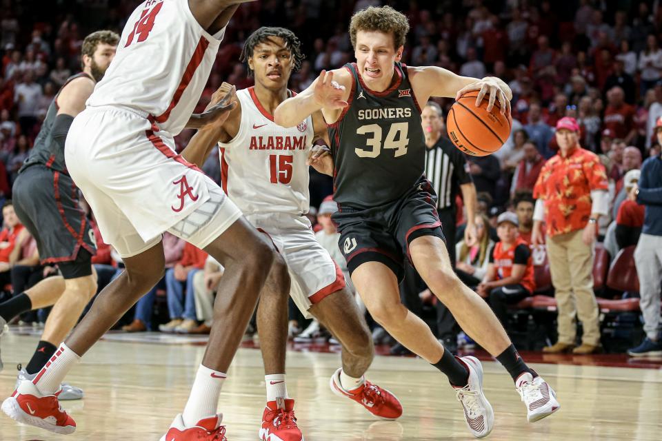 Oklahoma forward Jacob Groves (34) drives past Alabama center Charles Bediako (14) to shoot in the first half during a basketball game between The Oklahoma Sooners (OU) and The Alabama Crimson Tide at the Lloyd Noble Center in Norman, Okla., Saturday, Jan. 28, 2023.