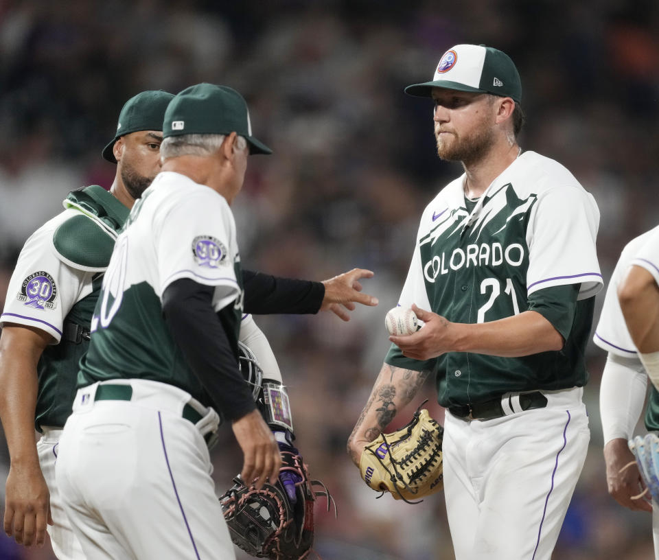 Colorado Rockies starting pitcher Kyle Freeland, right, hands the ball to manager Bud Black as Freeland is pulled from the mound in the sixth inning of a baseball game against the Atlanta Braves Wednesday, Aug. 30, 2023, in Denver. (AP Photo/David Zalubowski)