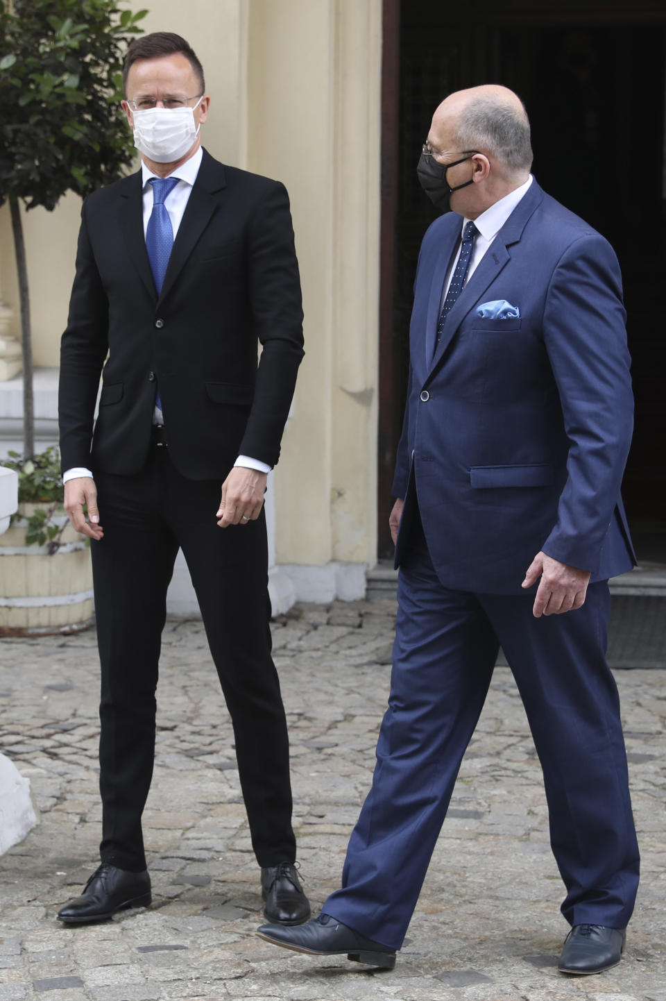 Poland's Foreign Minister Zbigniew Rau, right, walks with Hungarian Foreign Minister Peter Szijjarto during a meeting of foreign ministers from four central European countries known as the Visegrad Four in Lodz, Poland, Friday, May 14, 2021.(AP Photo/Czarek Sokolowski)