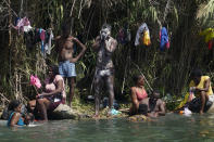 Haitian migrants bathe and do laundry along the banks of the Rio Grand after they crossed into the United States from Mexico, Saturday, Sept. 18, 2021, in Del Rio, Texas. (AP Photo/Eric Gay)