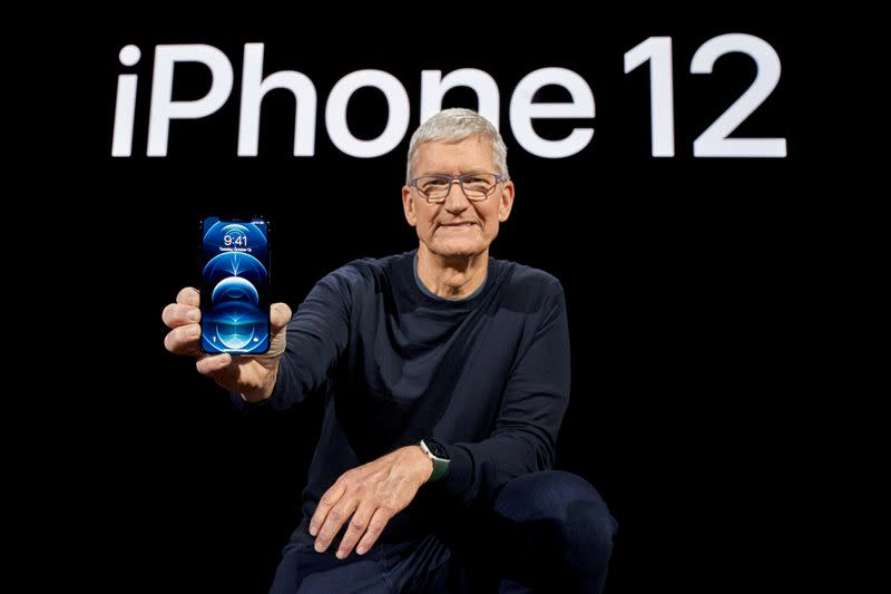 FILE PHOTO: Apple CEO Tim Cook poses with the iPhone 12 Pro at Apple Park in Cupertino