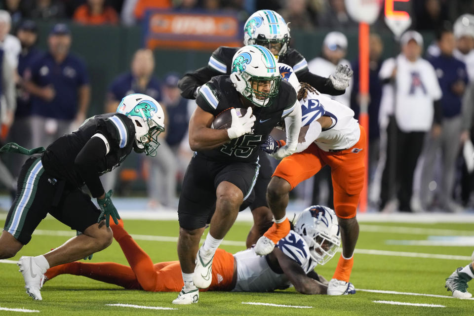 Tulane linebacker Jared Small (45) returns a fumble by UTSA running back Robert Henry, on ground, in the second half of an NCAA college football game in New Orleans, Friday, Nov. 24, 2023. Tulane won 29-16. (AP Photo/Gerald Herbert)