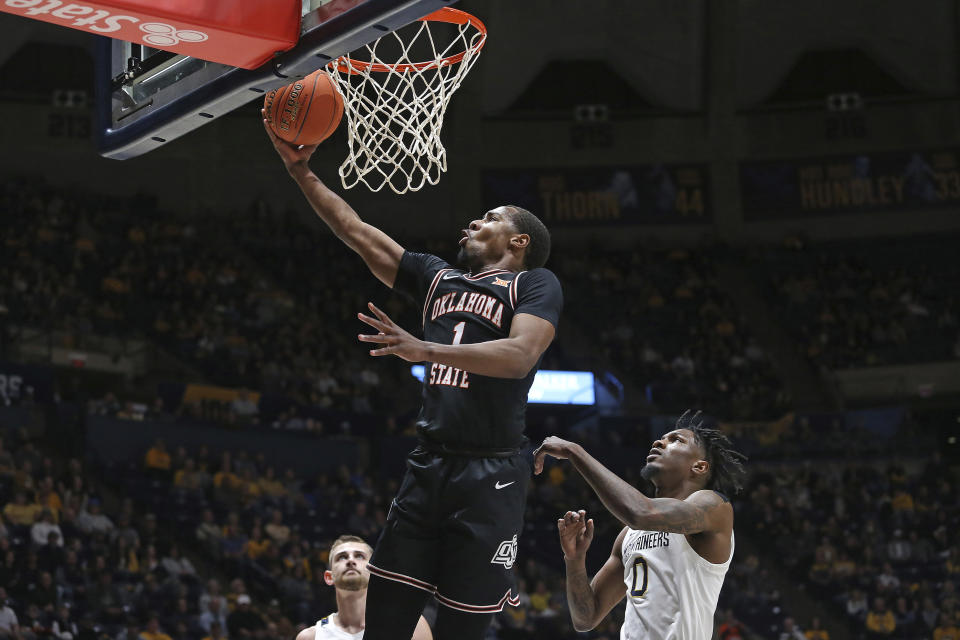 Oklahoma State guard Bryce Thompson (1) is defended by West Virginia guard Kedrian Johnson (0) during the first half of an NCAA college basketball game on Monday, Feb. 20, 2023, in Morgantown, W.Va. (AP Photo/Kathleen Batten)