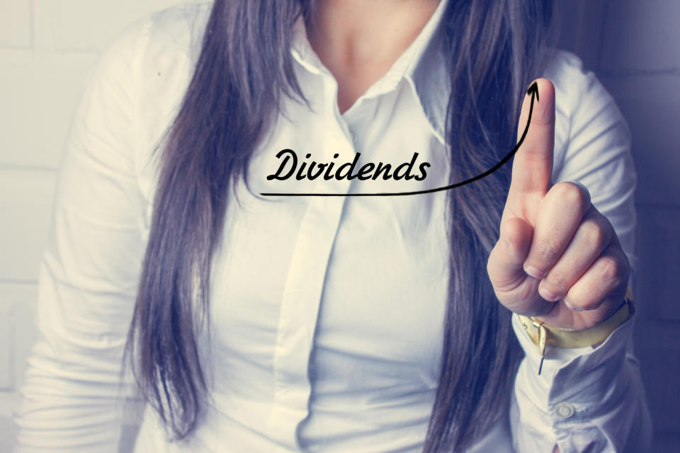 Woman writing the word dividends with her finger