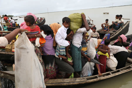 Rohingya refugees who arrived from Myanmar last night by boat, get into another boat to go to the main land, in Teknaf, Bangladesh, October 7, 2017. REUTERS/Mohammad Ponir Hossain