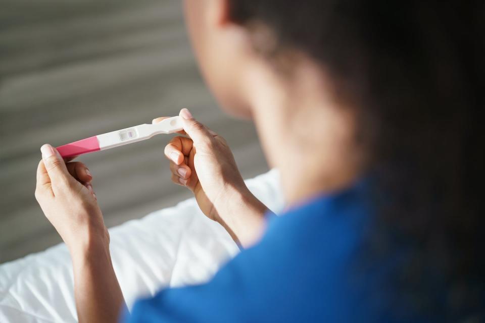 Woman holding negative pregnancy test.