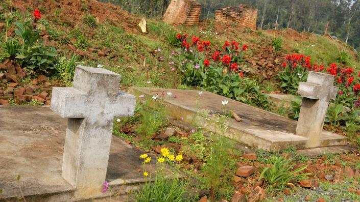 Photo dated 16 January 2004 shows a mass grave and in the background the ruins of the church of Notre Dame de la Visitation in Nyange where during the 1994 genocide some 2000 Tutsi were killed