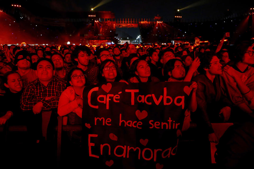 Los fans sostienen un cartel que dice "Café Tacvba, me hace sentir enamorada", en alusión a la letra de su famosa canción "Enamorada" durante un concierto en la Ciudad de México, el sábado 7 de diciembre de 2019. La banda mexicana festejó tres décadas de música con ese concierto masivo, en el que estrenaron una nueva versión feminista de “La ingrata” con Andrea Echeverri de Aterciopelados. (Foto AP/Anthony Vázquez)