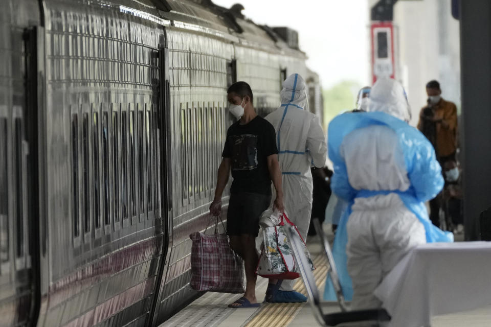 A man, who is among a group of people infected with COVID-19, gets into a train at Rangsit train station in Pathum Thani Province, Thailand to head to his hometown, Tuesday, July 27, 2021. Thai authorities began transporting some people who have tested positive with the coronavirus from Bangkok to their hometowns on Tuesday for isolation and treatment, to alleviate the burden on the capital’s overwhelmed medical system. (AP Photo/Sakchai Lalit)