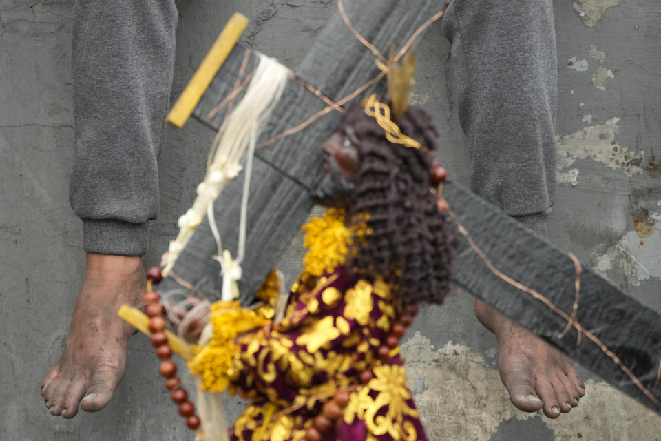 A barefoot devotee rests during the annual Black Nazarene procession which was resumed after a three-year suspension due to the coronavirus pandemic on Tuesday, Jan. 9, 2024 in Manila, Philippines. A mammoth crowd of mostly barefoot Catholic devotees joined a chaotic procession through downtown Manila Tuesday to venerate a centuries-old black statue of Jesus Christ with many praying for peace in the Middle East where Filipino relatives work. (AP Photo/Aaron Favila)