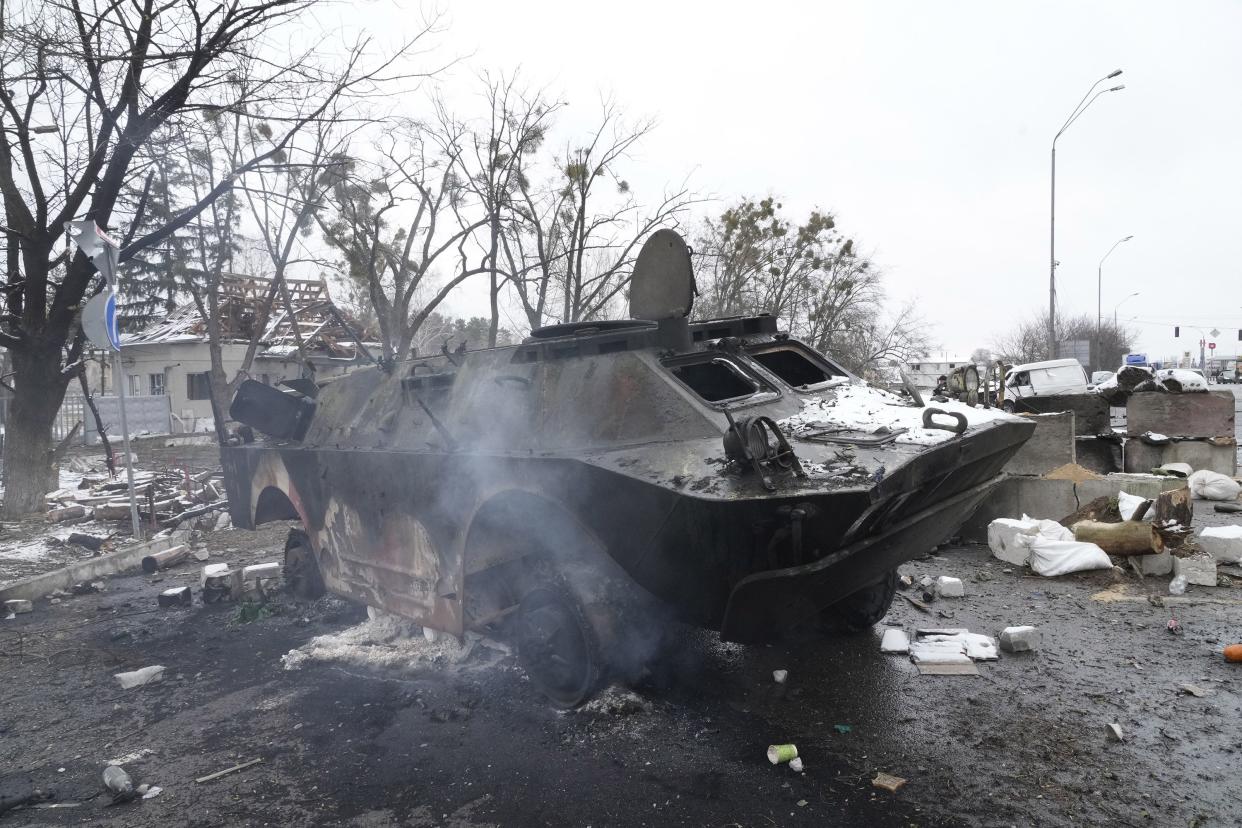 Smoke rises from a damaged armored vehicle at a checkpoint in Brovary, outside Kyiv, Ukraine, Tuesday, March 1, 2022.