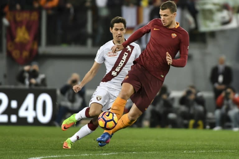 AS Roma's Edin Dzeko (R) fights for the ball with Torino's Sasa Lukic during their Italian Serie A match, at Rome's Olympic stadium, on February 19, 2017