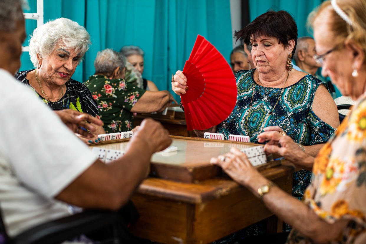 Olga Ayala, 91, left, Emely Santana, 71, center, and Hilda R. D’az, 87, play dominoes at the Center for Activities and Multiple Uses for the Elderly of Toa Baja in Toa Baja, Puerto Rico, on May 26, 2023. (Erika P. Rodríguez for NBC News)