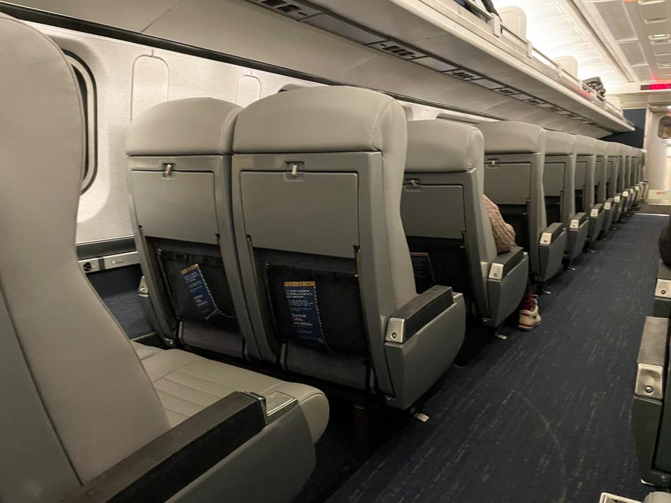 Rows of empty passenger seats. Many are empty.