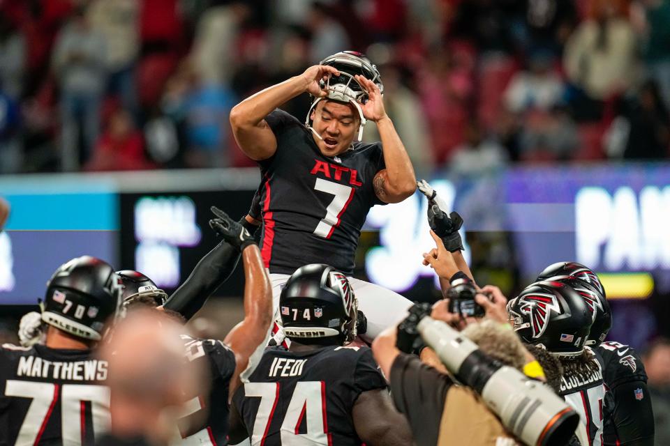 Younghoe Koo is lifted up by teammates after kicking the winning field goal in overtime against the Carolina Panthers.