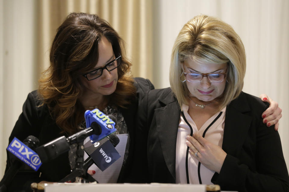 As Patty Fortney-Julius, left, offers support, her sister Lara Fortney McKeever cries as she speaks to reporters during a news conference in Newark, N.J., Monday, Dec. 2, 2019. The two sisters from Pennsylvania are suing the Archdiocese of Newark and the Diocese of Harrisburg, Pennsylvania. They allege clergy in Newark knew a priest had sexually abused children before he moved to Harrisburg and abused them and their sisters for years. Lawsuits alleging sexual abuse by Roman Catholic clergy are taking center stage in New Jersey as the state's relaxation of statute of limitations rules takes effect. (AP Photo/Seth Wenig)