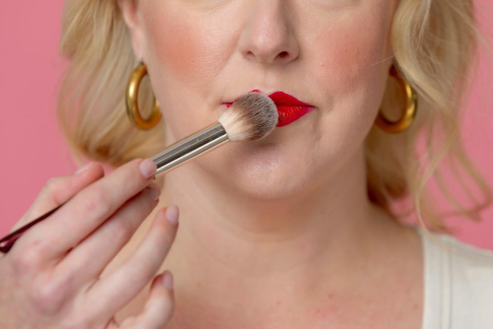 Brush translucent powder over your lipstick.