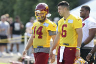 Washington Football Team quarterbacks Ryan Fitzpatrick (14) and Steven Montez (6) take the field during NFL football practice in Richmond, Va., Wednesday, July 28, 2021. (AP Photo/Ryan M. Kelly)