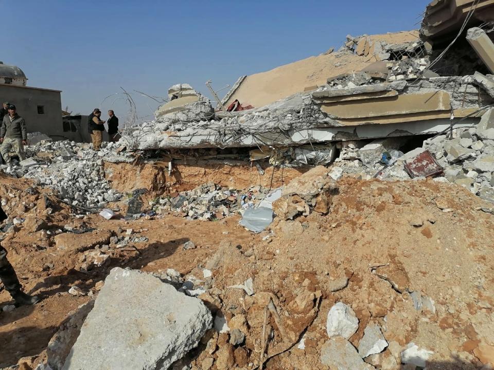 Fighters from the Kataeb Hezbollah, or Hezbollah Brigades militia, inspect the destruction of their headquarters in the aftermath of a U.S. airstrike in Qaim, Iraq, Monday, Dec. 30, 2019. The Iranian-backed militia said Monday that the death toll from U.S. military strikes in Iraq and Syria against its fighters has risen to 25, vowing to exact revenge for the "aggression of evil American ravens." (AP Photo)