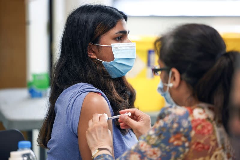 A person receives a dose of the Pfizer BioNTech vaccine at a vaccination centre for those aged over 18 at the Belmont Health Centre in Harrow, amid the coronavirus disease (COVID-19) outbreak in London