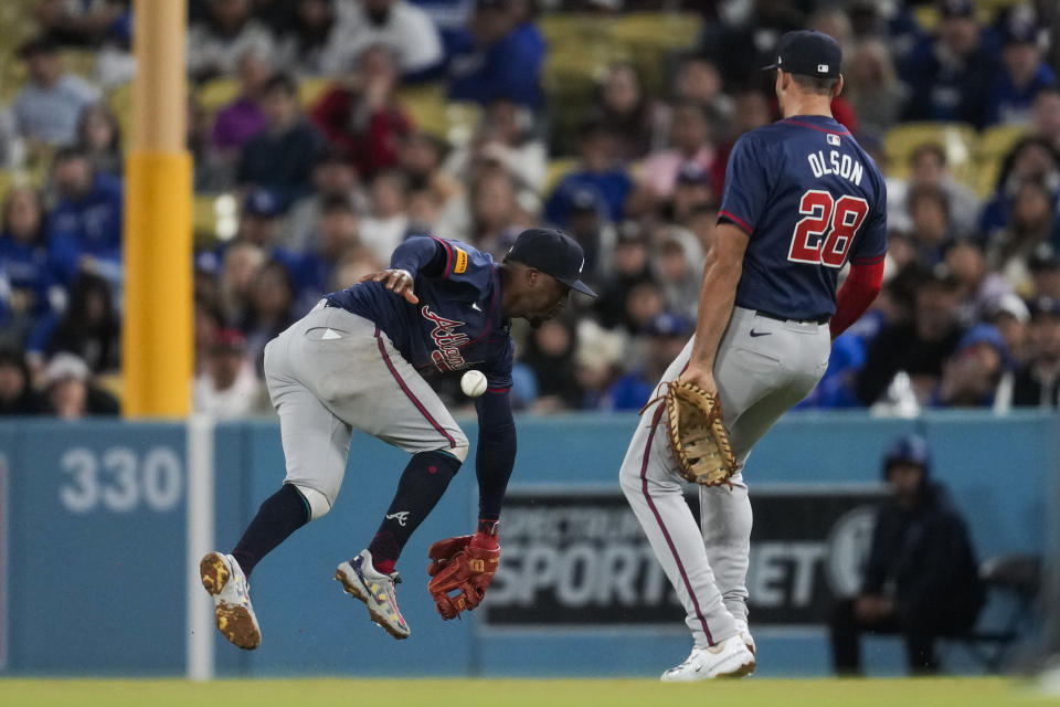 Atlanta Braves second baseman Ozzie Albies, left, does not catch a fly ball hit by Los Angeles Dodgers' Mookie Betts during the seventh inning of a baseball game in Los Angeles, Saturday, May 4, 2024. Atlanta Braves first baseman Matt Olson is at right. (AP Photo/Ashley Landis)