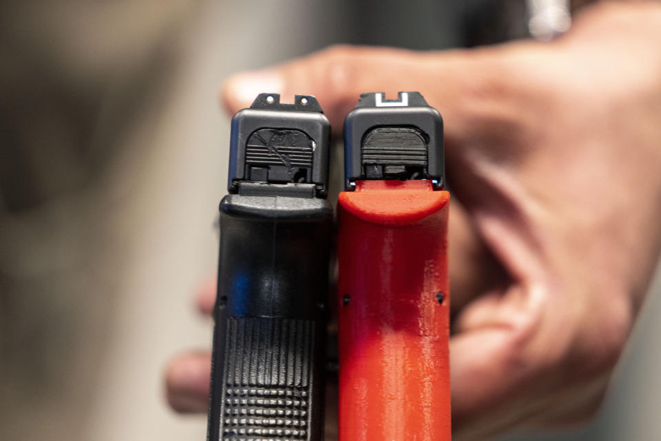 Two semi-automatic pistols are displayed for a photograph, one with a conversion device installed making it fully automatic, at the Bureau of Alcohol, Tobacco, Firearms, and Explosives (ATF), National Services Center, Thursday, March 2, 2023, in Martinsburg, W.Va. Machine guns have been illegal in the U.S. for decades, but in recent years the country has seen a new surge of weapons capable of automatic fire. Small pieces of plastic or metal used to convert legal guns into homemade machine guns are helping to fuel gun violence. (AP Photo/Alex Brandon)