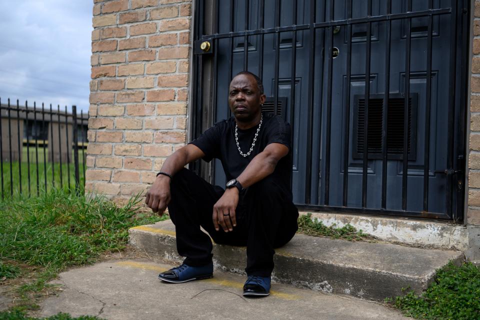 Marlon Coleman sitting on a step outside his old home.