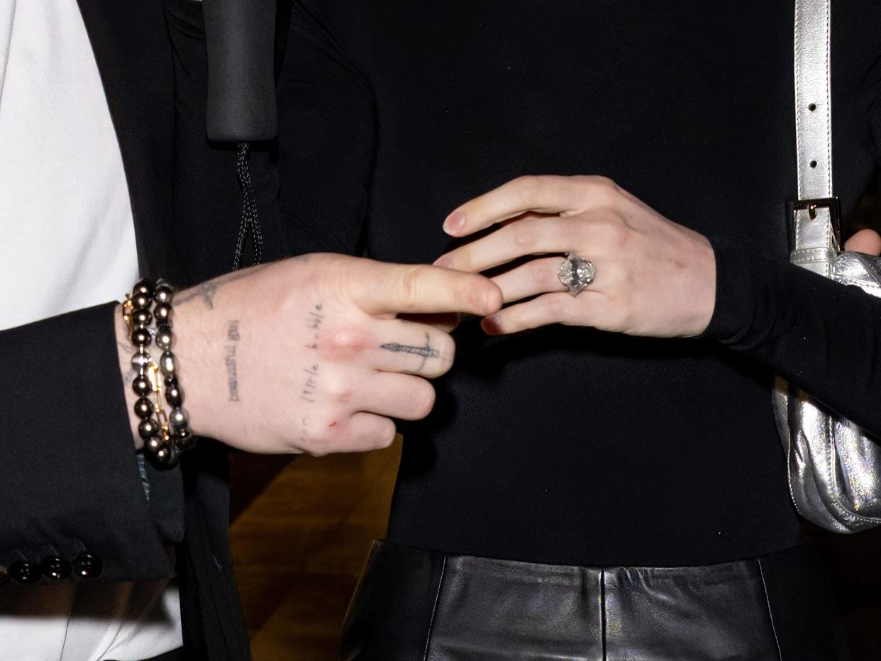 Brooklyn Beckham and Nicola Peltz with wedding ring visible.