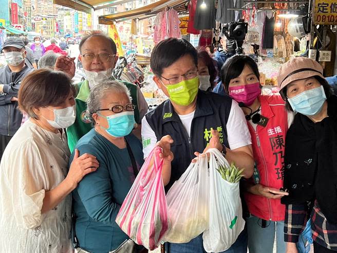 有攤商拿出包子、粽子以及鳳梨，要祝福林佳龍「包中」、「運氣旺」。（李奇叡攝）