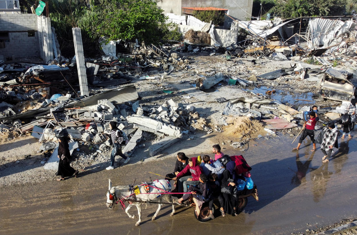 Displaced Palestinians leave to try to return to their homes, passing by a house destroyed in an earlier Israeli airstrike, during a short-term cease-fire in the Israel-Hamas war, Nov. 24, 2023, in Khan Younis, southern Gaza Strip. / Credit: MOHAMMED SALEM/REUTERS