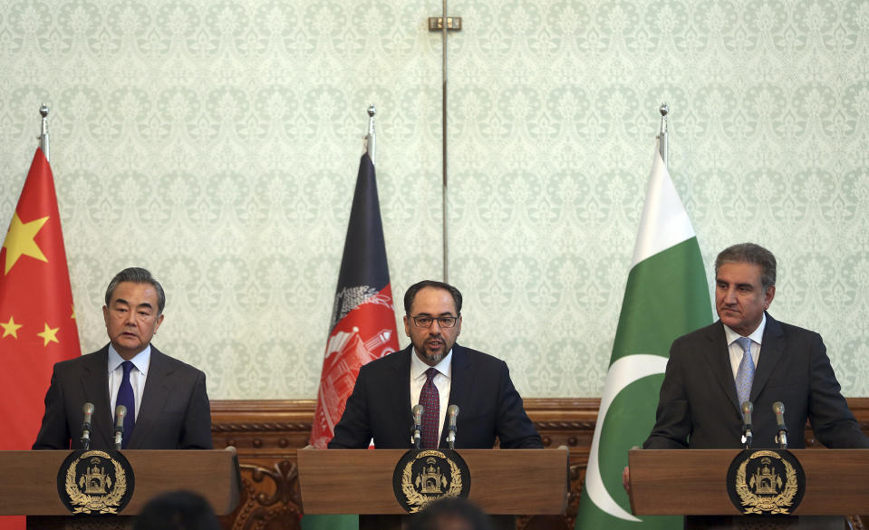 Afghanistan's Minister of Foreign Affairs Salahuddin Rabbani, center, speaks as Pakistan's Foreign Minister Shah Mehmood Qureshi, first right, and Chinese Foreign Minister Wang Yi, first left, listen during a joint press conference at the presidential palace in Kabul, Afghanistan, Saturday, Dec. 15, 2018. Afghanistan, Pakistan, and China are meeting in the Afghan capital to discuss trade, development and ending the region's relentless conflicts. (AP Photo/Massoud Hossaini)