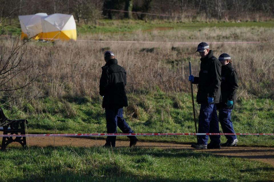 Police searching the murder scene at the park (PA)