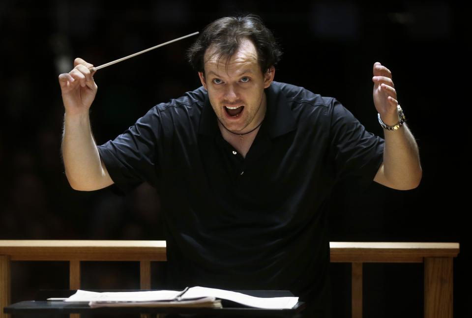 FILE — In this Nov. 20, 2014 file photo, Boston Symphony Orchestra music director Andris Nelsons rehearses with the orchestra at Symphony Hall, in Boston. Nelsons has reached agreement on contract extensions with both the Boston Symphony Orchestra and the Gewandhausorchester of Leipzig, Germany, the parties announced on Monday, Oct. 5. With the three-year contract extension, Nelsons is to remain the BSO's music director through the the 2024-25 season. (AP Photo/Steven Senne, File)