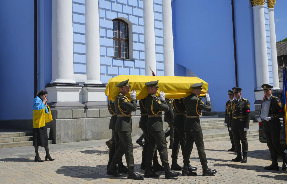 Soldiers carry a coffin with remains of a volunteer soldier Oleksandr Makhov, a well-known Ukrainian journalist, killed by the Russian troops, at St Michael cathedral in Kyiv, Ukraine, Monday, May 9, 2022. The coffin is followed by Makhov's widow.(AP Photo/Efrem Lukatsky)