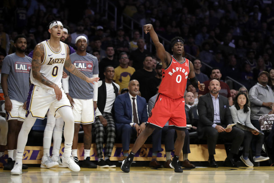 Toronto Raptors' Terence Davis follows through as he makes a 3-point basket next to Los Angeles Lakers' Kyle Kuzma (0) during the second half of an NBA basketball game Sunday, Nov. 10, 2019, in Los Angeles. (AP Photo/Marcio Jose Sanchez)