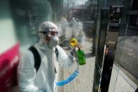 Employees from a disinfection service company sanitize a shopping district in Seoul