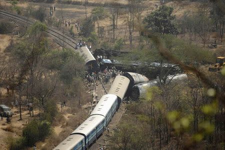 Rescuers and police stand next to damaged coaches of a passenger train after it derailed near Nidi village in Maharashtra May 4, 2014. REUTERS/Stringer