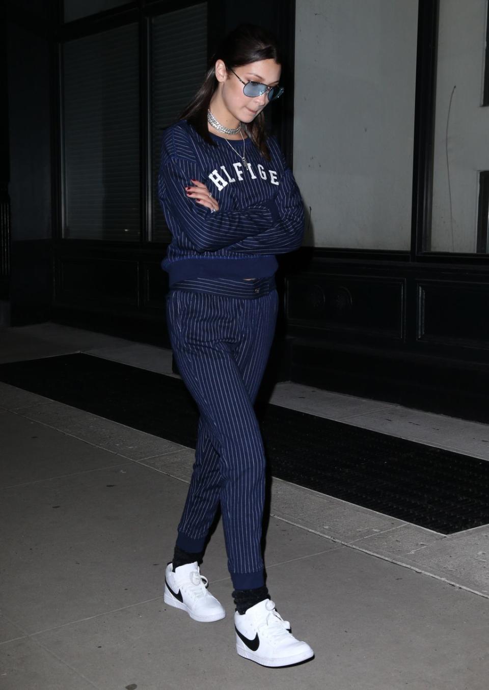 <p>In a navy blue pinstriped Tommy Hilfiger tracksuit with white Nike sneakers and blue-tinted sunglasses while out in New York City. </p>