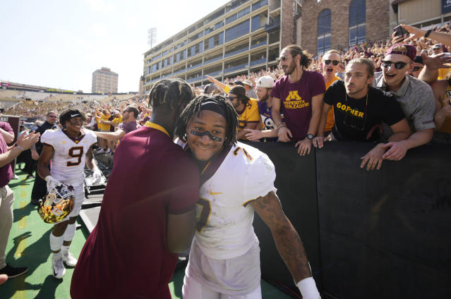 Minnesota wide receiver Chris Autman-Bell, front right, is congratulated by a cheerleader after an NCAA college football game against Colorado, Saturday, Sept. 18, 2021, in Boulder, Colo. Minnesota won 30-0. (AP Photo/David Zalubowski)