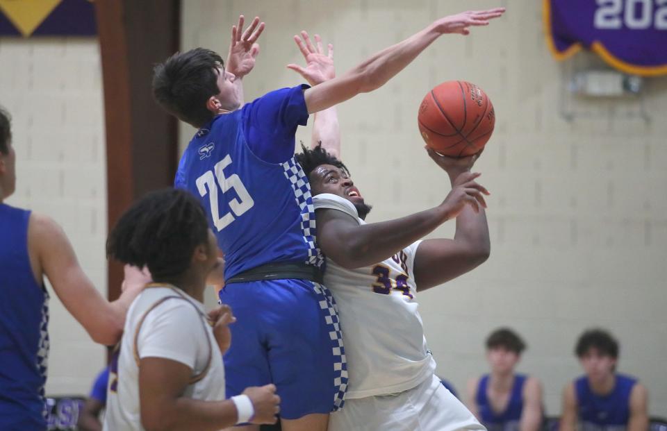 OLSH's BJ Vaughn (34) goes for a layup while being heavily guarded by South Park's Daniel Battista (25) during the first half Friday night at Our Lady of the Sacred Heart High School.