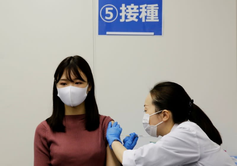 FILE PHOTO: A staff of All Nippon Airways (ANA) receives a dose of the Moderna COVID-19 vaccine at the company's facility at Haneda airport in Tokyo